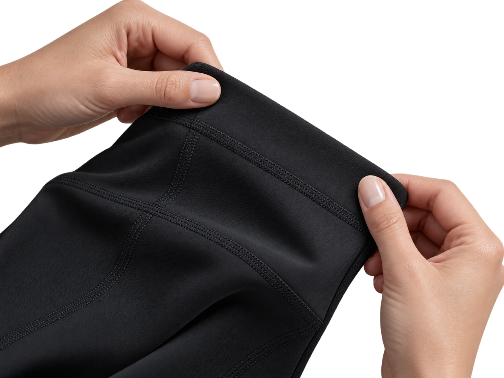 Mãos examinando a costura e o acabamento da legging preta.